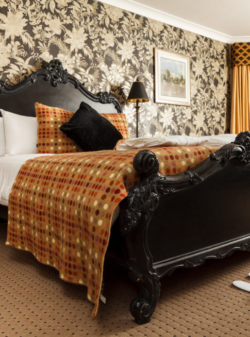 double bed with ornate headboard in privilege room at mercure bristol north the grange hotel