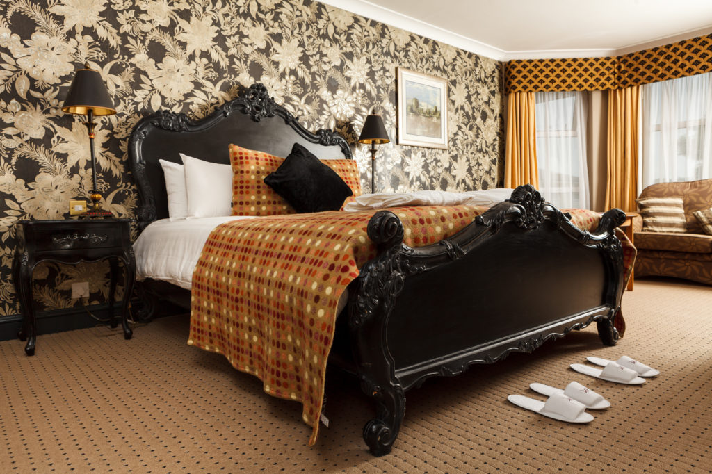 double bed with ornate headboard in privilege room at mercure bristol north the grange hotel